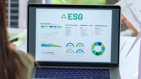 Kobieta spoglądająca na ekran komputera z informacjami o ESG