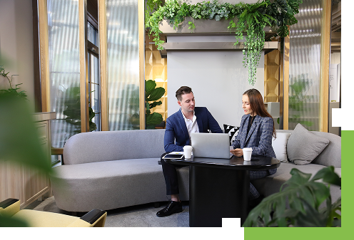 Kobieta i mężczyzna siedzący przy komputerze i omawiający coś wspólnie.